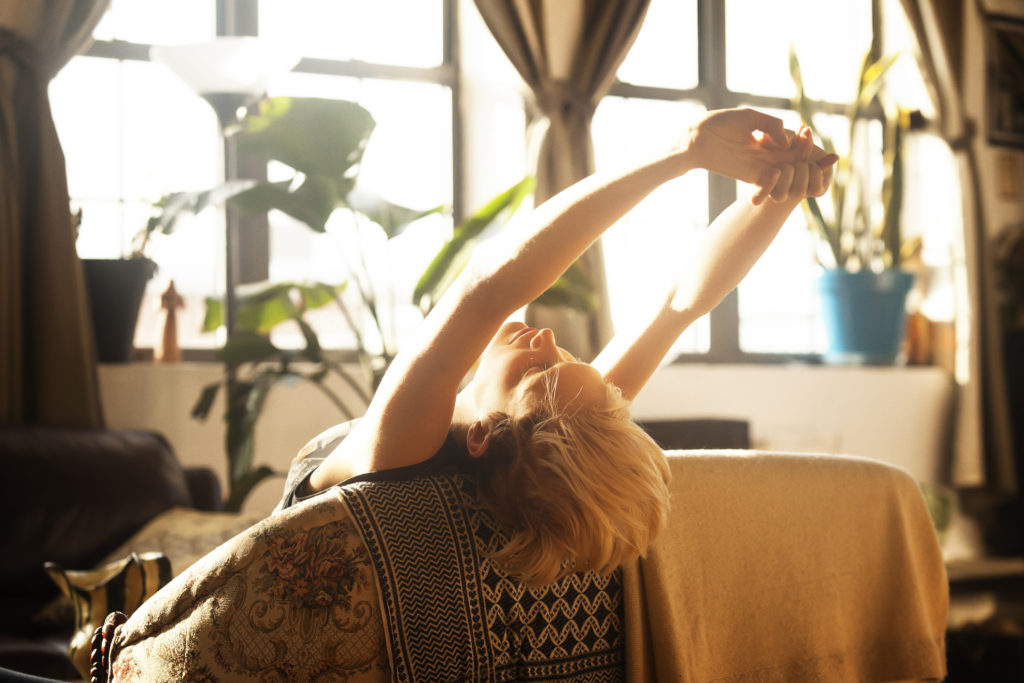 Woman WFH stretching at laptop