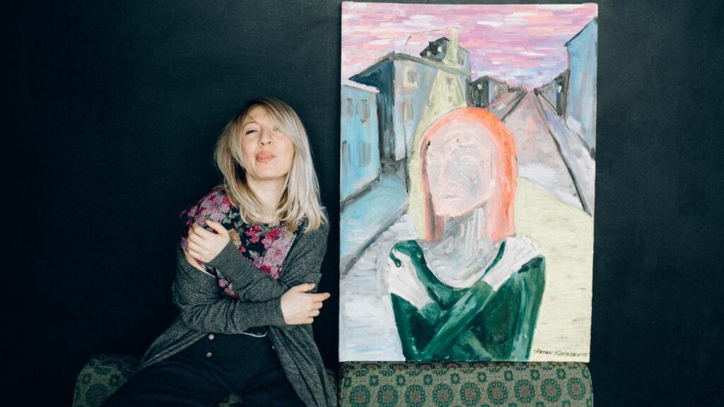 Woman standing beside artwork she painted