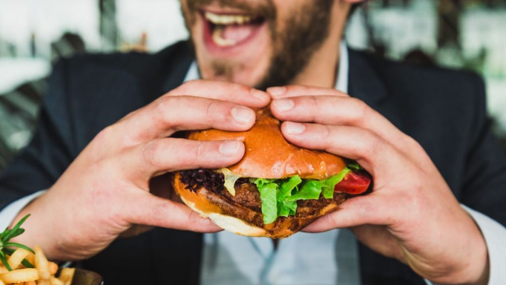 Man eating hamburger as taste tester