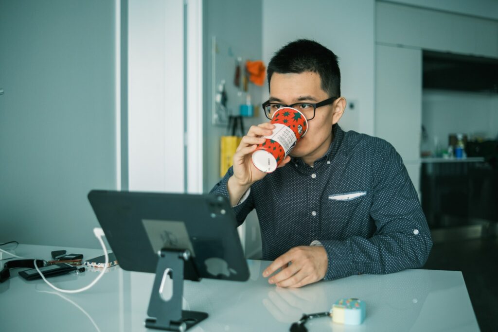 Man drinking coffee while working