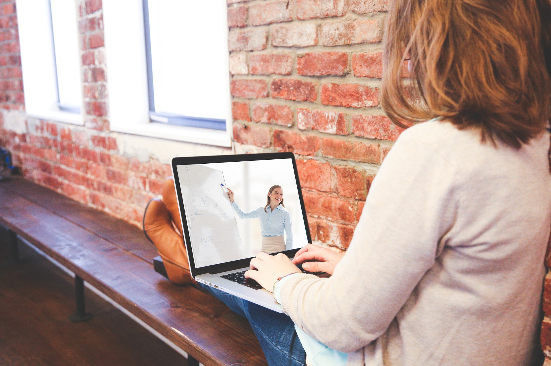 Woman watching teacher on laptop