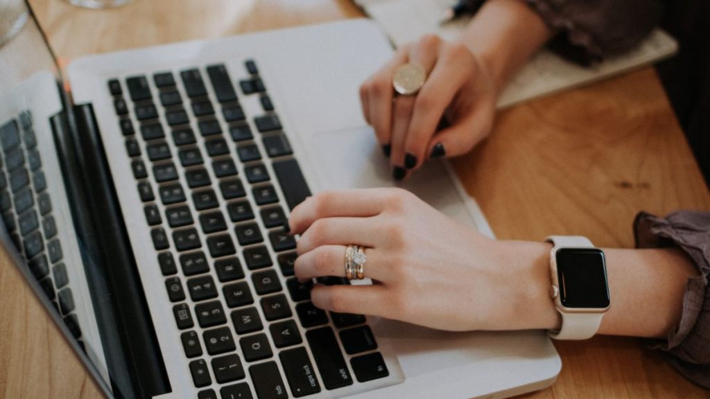 Woman typing domain name on laptop