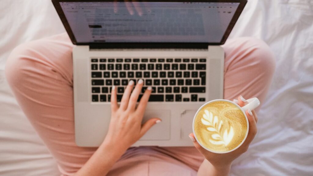 Woman working on blog on laptop with cup of coffee