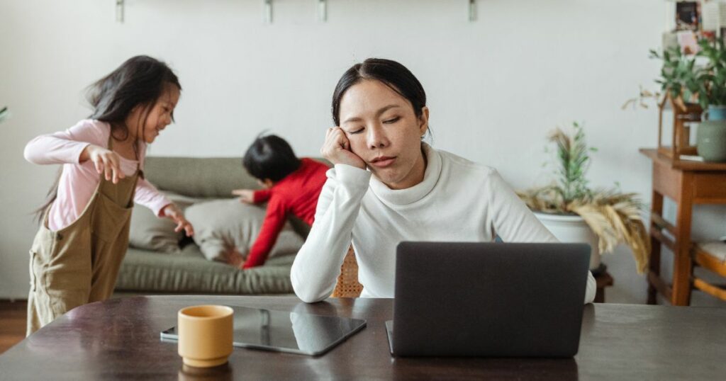 Woman trying to work at home on laptop