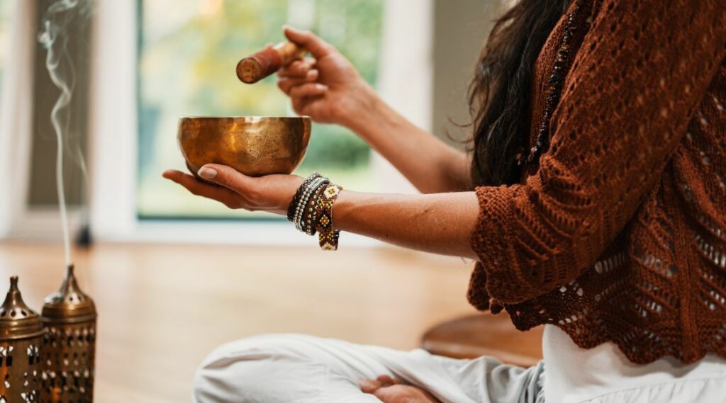 Woman holding copper bowl for meditation