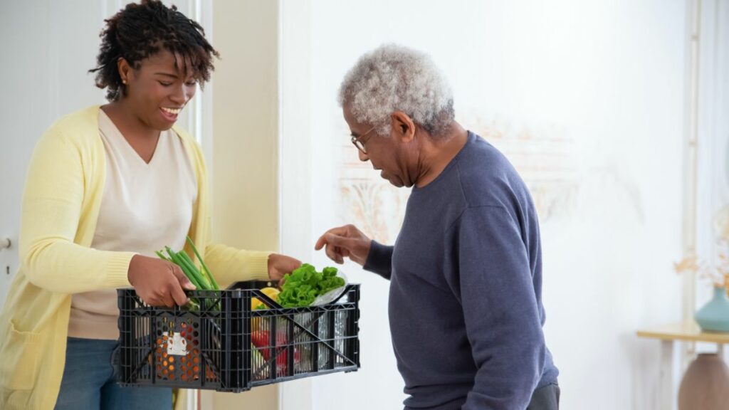 Woman giving vegetables to man in need