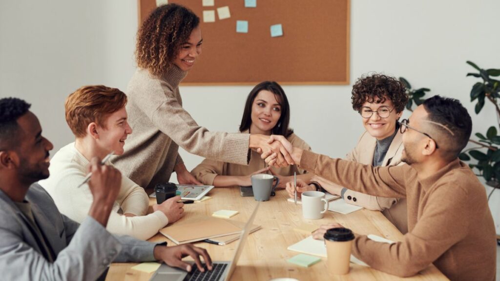 Woman shaking hands with man during a team meeting