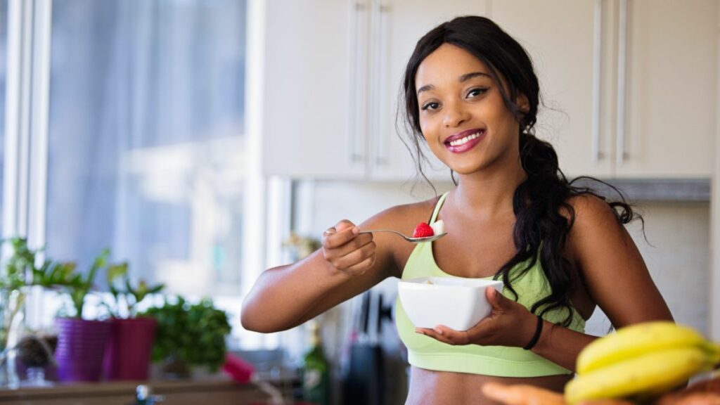 Happy woman eating healthy breakfast during morning ritual